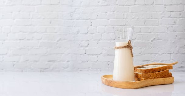 Bottle of milk and sliced breads on kitchen table. - Photo, image