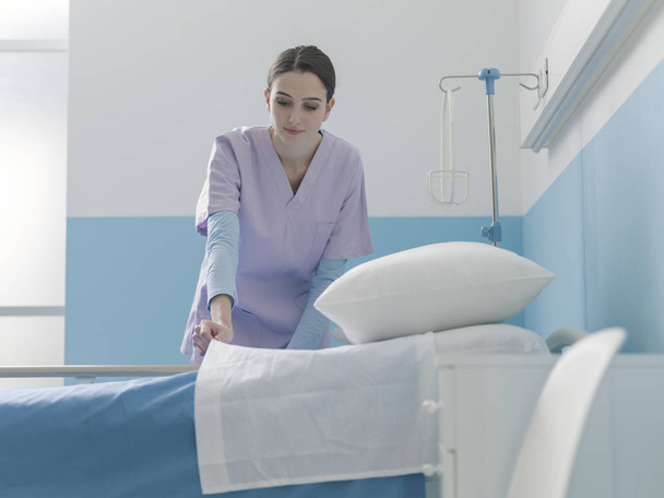 Asiantuntija nuori sairaanhoitaja petaa sängyn sairaalassa
 - Valokuva, kuva