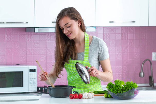 Kobieta w fartuchu przygotowuje potrawy z dojrzałych warzyw dla rodziny na obiad w kuchni w domu. Czyste jedzenie i prawidłowe odżywianie. Zdrowy styl życia, dieta  - Zdjęcie, obraz