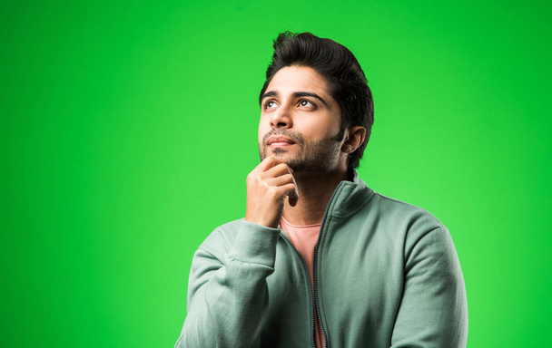 Indiano giovane uomo pensare contro verde chroma chiave di sfondo - Foto, immagini