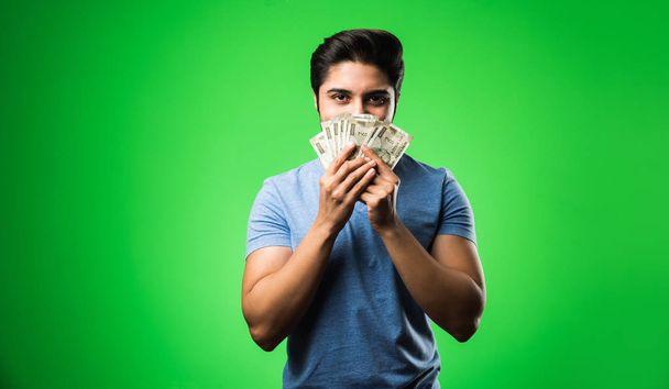 Indiano feliz homem segurando dinheiro, de pé isolado contra tela croma verde - Foto, Imagem