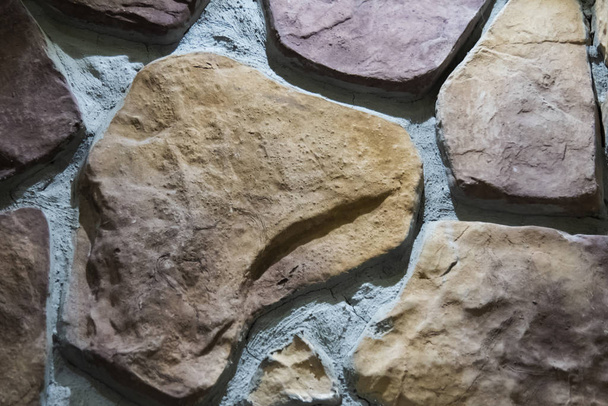Fragmento de uma parede de pedras grandes vermelho-marrons
. - Foto, Imagem