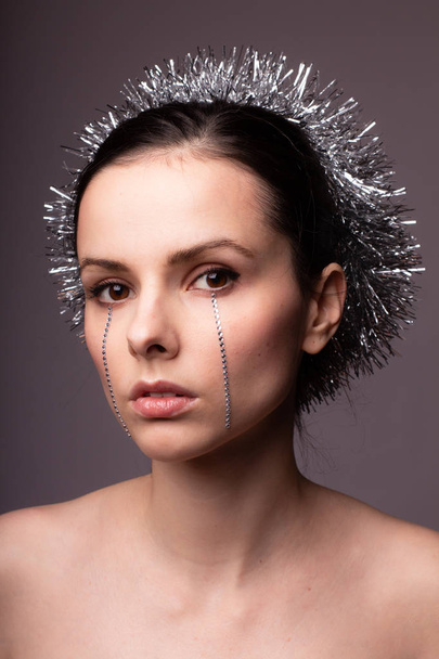 beautiful girl in a brilliant rim with rhinestones on her face - Foto, afbeelding
