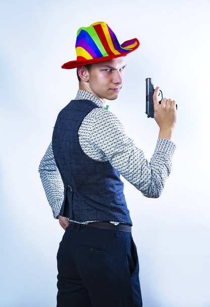 Funny handsome man with a gun as a cowboy in carnival. The cowboy turns around. Back view - Photo, image
