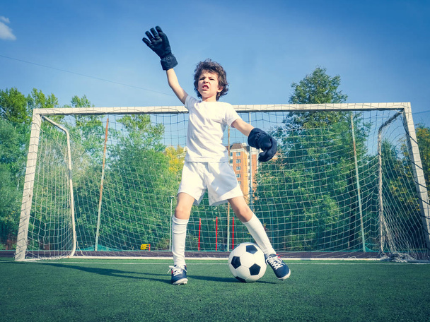Summer soccer tournament for young kids. football club. emotions and joy of the game. Young goalie. Kids - soccer champion. Boy goalkeeper in football sportswear on stadium with ball. Sport concept. - Foto, immagini