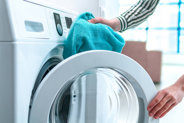 Loading towel, clothes and linen in washing machine. Doing laundry at home. Household chores and housekeeping - Foto, immagini