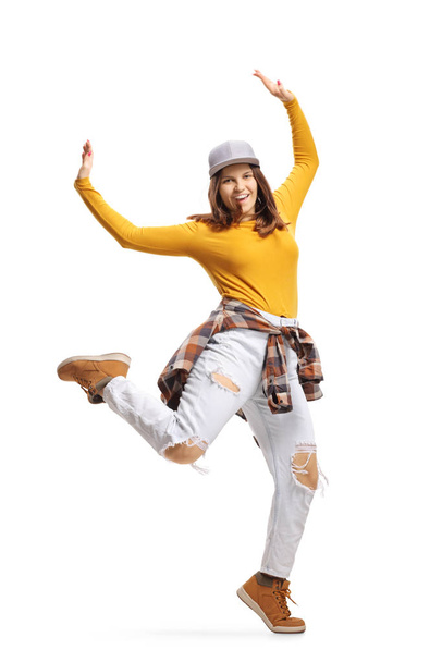 Ευτυχισμένη νεαρή γυναίκα που χορεύει με σηκωμένα χέρια - Φωτογραφία, εικόνα