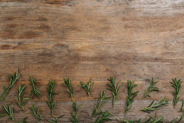 Flat lay composition with fresh rosemary on wooden table. Space for text - Fotografie, Obrázek