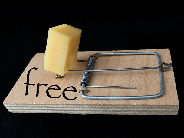 Δωρεάν τυρί σε ποντικοπαγίδα σε μαύρο φόντο. Ξύλινη παγίδα με δόλωμα και μηχανισμό για αρουραίους και ποντίκια. - Φωτογραφία, εικόνα