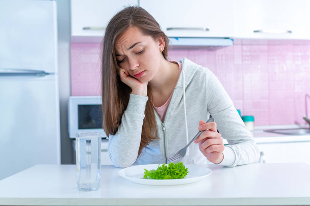 Sad unhappy young woman is tired of dieting and not wanting to eat organic, clean healthy food - Fotoğraf, Görsel