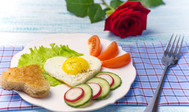 Romanttinen aamiainen ystävänpäivänä. Sydämen muotoinen munakas terveellisiä vihanneksia
. - Valokuva, kuva