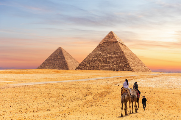 Pyramides égyptiennes de Gizeh et les touristes sur un chameau
 - Photo, image
