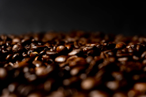 Close-up van vers gebrande bruine koffiebonen - hoekig uitzicht met kopieerruimte - Foto, afbeelding