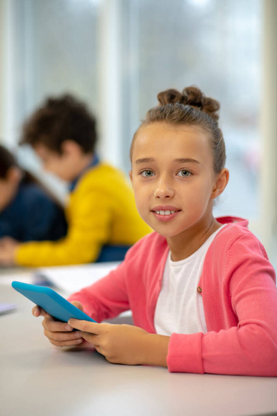 Pretty girl enjoying using modern devices at school - Photo, Image