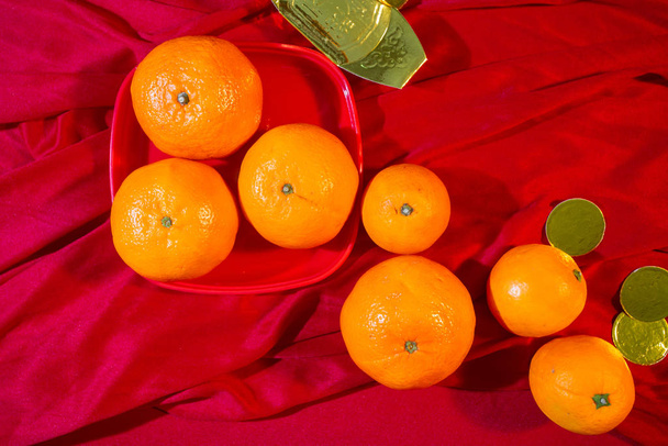 Oranges and gold on red fabric , Chinese New Year - Photo, Image