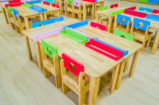 Schreibtische und Stühle im Klassenzimmer des Kindergartens. - Foto, Bild
