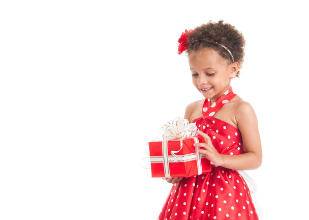 Little beautiful mulatto girl with gifts. - 写真・画像