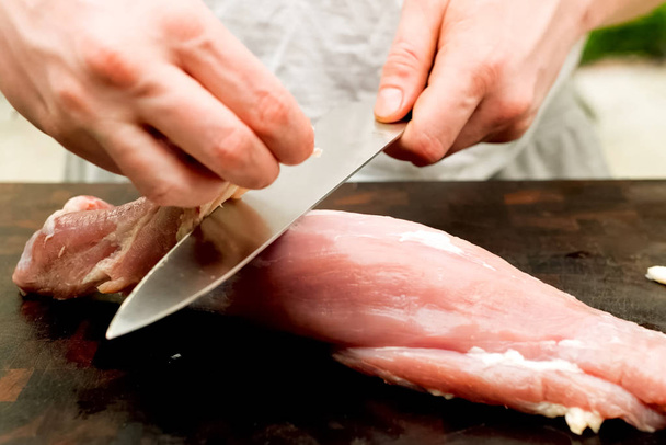 Cutting piece of pork meat on the table. Raw pork. - Photo, Image