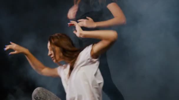 Two young women dancing in smoky studio - Πλάνα, βίντεο