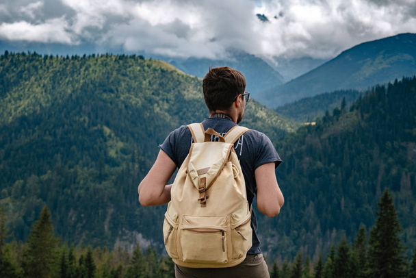 Чоловік ходить по горах з важким рюкзаком
 - Фото, зображення