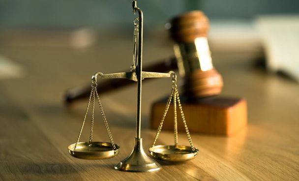 Scales and gavel on wooden table background with blurred books - Photo, image