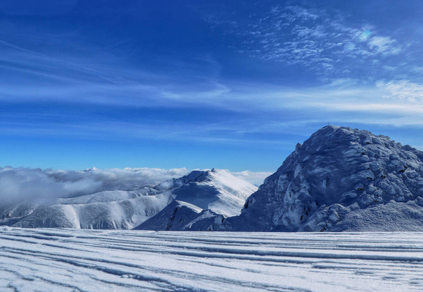 Az Alacsony-Tátra Nemzeti Park havas dombjai. Kilátás a legmagasabb csúcsok a régióban - Chopok és Dumbier. A hülyébbet felhők borítják. Szerencsés, hogy a felhők felett van. Demanovska-völgy, Szlovákia - Fotó, kép