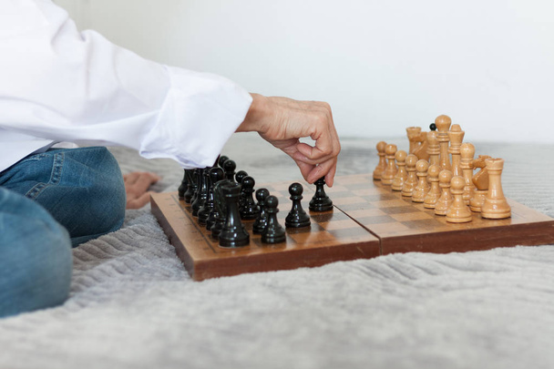 Strategy concept, hand of woman moving wooden chess figure in pl - Foto, Imagen