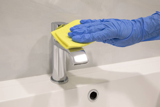 Persona mano En guante azul limpieza mezclador lavabo de plata y fregadero blanco
 - Foto, Imagen