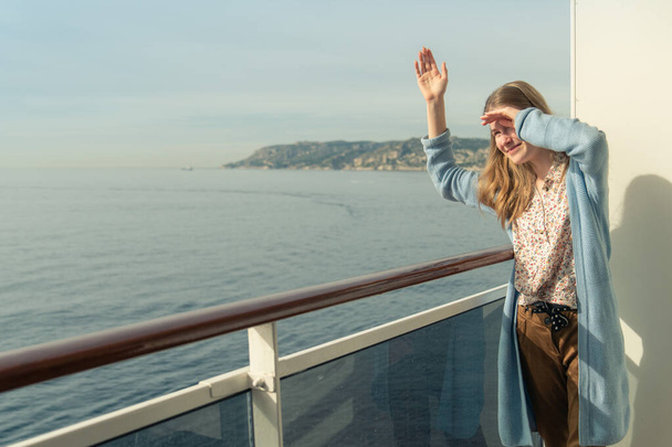 Cruise ship vacation. Teenager girl relaxing on luxury cruise ship balcony. Portrait of a happy beautiful girl on a cruise ship at sunrise - Foto, Imagen