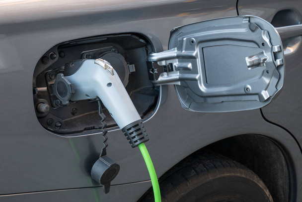 Detailní záběr plně elektrické zásuvky kabelu pro automobil s připojeným nabíjecím kabelem - Fotografie, Obrázek