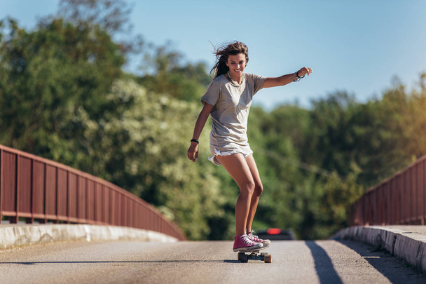 道路上のスケートボードに乗ってスポーティ女性。ロングボード, - 写真・画像