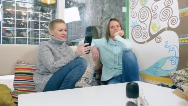 two women are sitting together in an informal cafe - Footage, Video