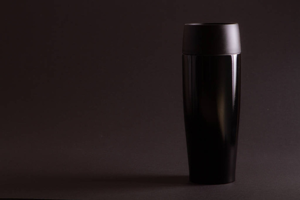 one black thermal bottle shaker for sports nutrition on a black  - Foto, imagen