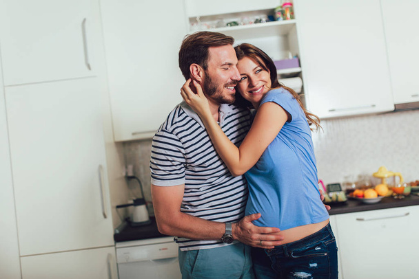 вагітна жінка з чоловіком на кухні
 - Фото, зображення