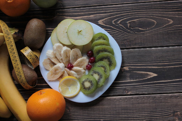Banaanit, kiivit, omenat, marjat ja appelsiini pöydällä
. - Valokuva, kuva
