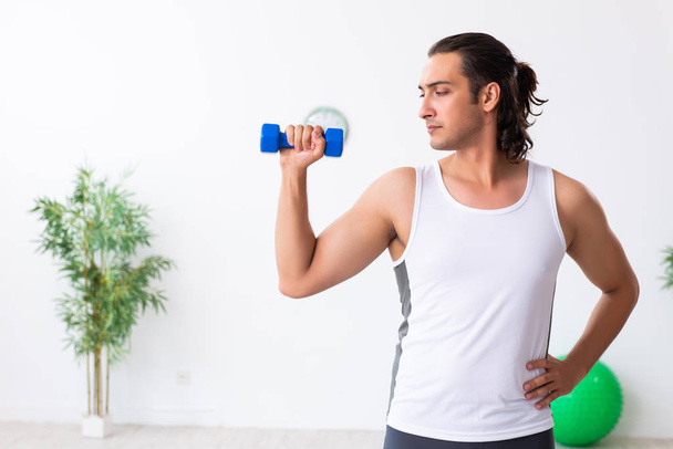 Young handsome man doing sport exercises indoors - Photo, Image