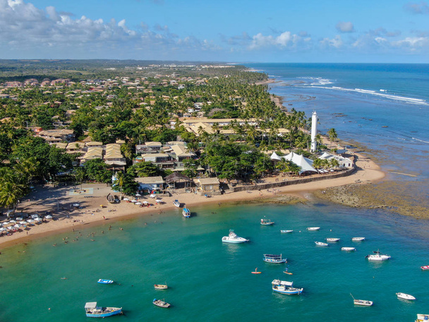 Vista aérea del pueblo costero de Praia Do Forte con playa y agua azul clara de mar
 - Foto, Imagen