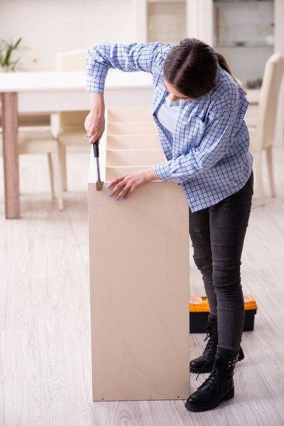 Young beautiful woman assembling furniture at home - Photo, Image