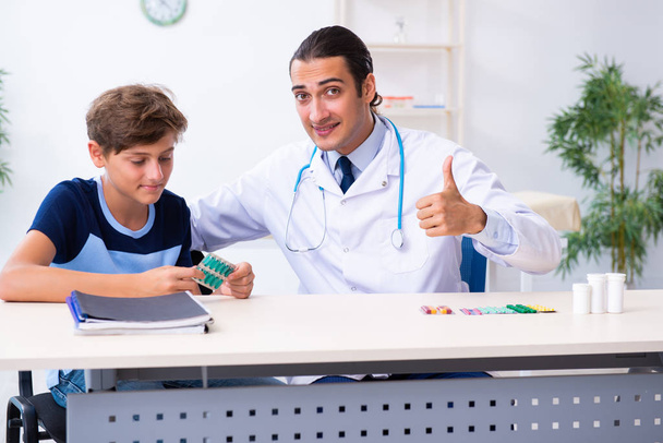 Jonge mannelijke arts onderzoeken jongen in de kliniek - Foto, afbeelding