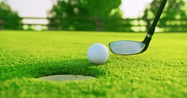 Golf tette egy ember a zöld. A labda elsüllyed a lyukba. Közelkép. - Felvétel, videó