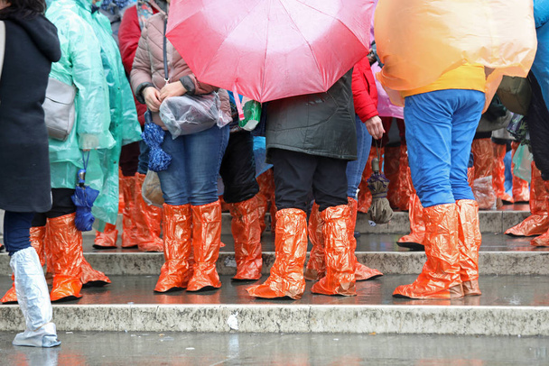 άτομα με βάτες και αδιάβροχα αδιάβροχα και ομπρέλες - Φωτογραφία, εικόνα