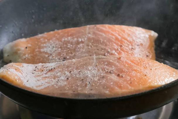 Frying red fish in pan. Pieces of red fish. - Photo, Image