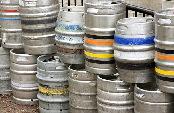barriles de cerveza de metal apilados fuera de un bar
 - Foto, Imagen