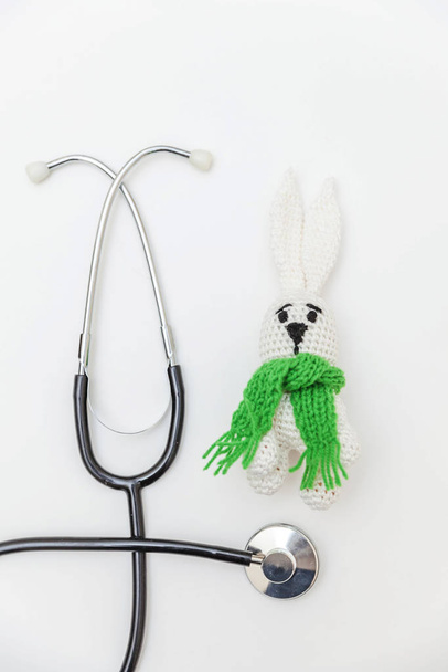 Просто минимальный дизайн игрушки кролика и медицинского оборудования стетоскоп изолированы на белом фоне. Здравоохранение детский врач концепция. Символ педиатра. Плоская ложа, пространство для копирования сверху
 - Фото, изображение