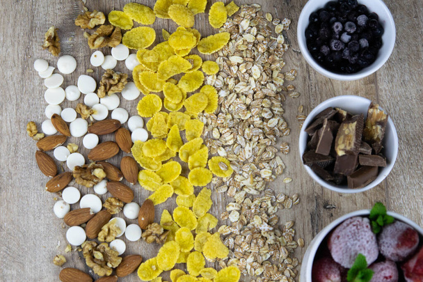 Zdrowe śniadanie z musli, owoców, jagód na drewnianym tle - Zdjęcie, obraz