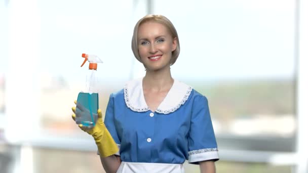 Mooie glimlachende huishoudster met reinigingsspray. - Video