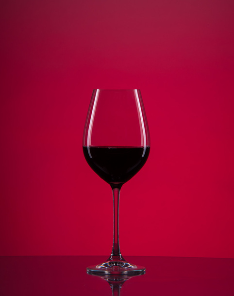 kırmızı arka planlı şarap kadehi - Fotoğraf, Görsel