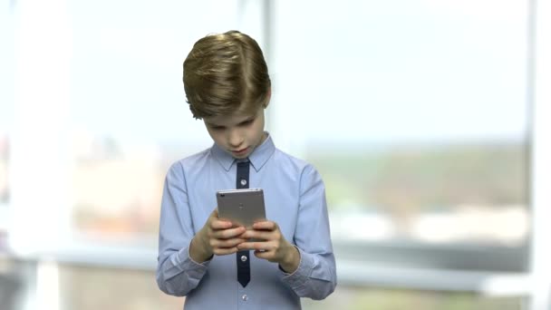 χαριτωμένο μικρό αγόρι που χρησιμοποιούν smartphone. - Πλάνα, βίντεο