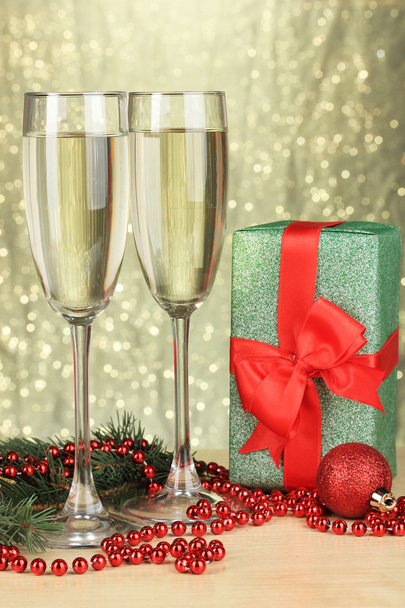 Glasses of champagne with gift box on shiny background - Foto, imagen