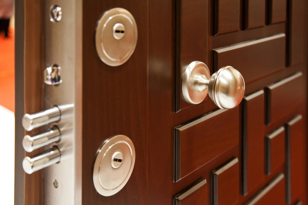 Σύγχρονη ξύλινη πόρτα αναζητούν χάλυβα, σύστημα κλειδώματος ασφαλείας - Φωτογραφία, εικόνα
